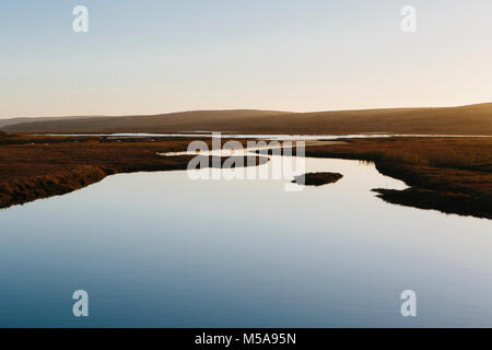 The open spaces of marshland and water channels. Flat calm water. Stock Photo