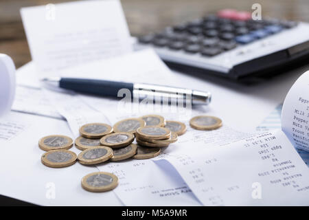 Close-up Of Metallic Coins And Pen On Receipt Stock Photo