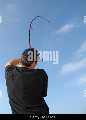 fishing scene, fish fight, angler fighting with a big fish. The rod is bending Stock Photo