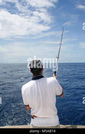 a fisherman in a boat fight against a fish. Deep sea fishing Stock Photo