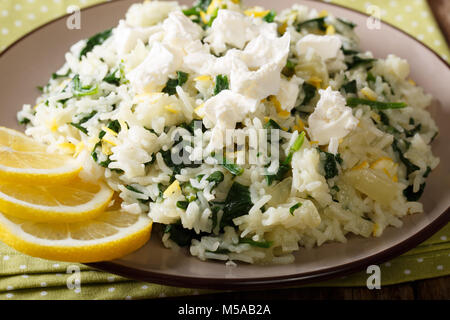 Greek cuisine: spanakorizo rice with spinach and feta cheese on a plate close-up. horizontal Stock Photo