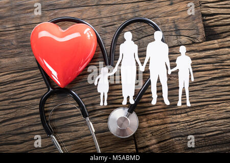 Elevated View Of Family Cut Out And Red Heart With Stethoscope On Desk Stock Photo