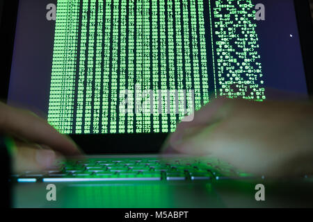 Close-of A Hacker's Hand Using Laptop With Binary Code On Screen Stock Photo