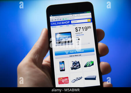Close-up Of Person's Hand Shopping Online On Mobile Phone Over Blue Background Stock Photo
