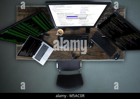 High Angle View Of Multiple Computer Screen Showing Progress Bar Of Copying File On Desk Stock Photo