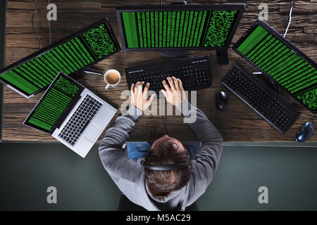 High Angle View Of Hacker Stealing Data From Multiple Computer Stock Photo