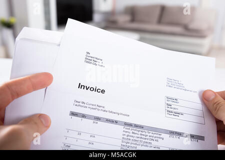 Close-up Of A Person's Hand Holding Invoice Stock Photo