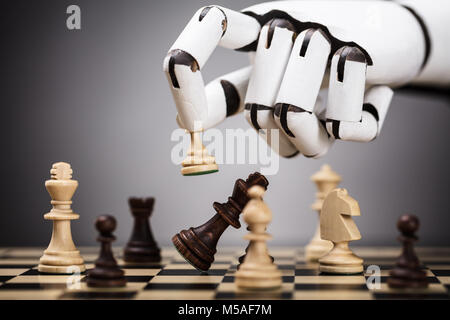 Close-up Of A Robot's Hand Playing Chess Stock Photo
