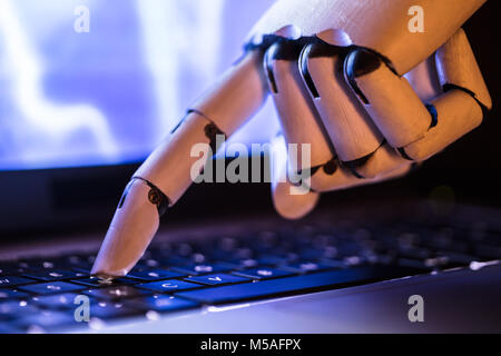 Close-up Of A Robot's Hand Typing On Laptop Stock Photo