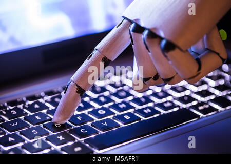 Close-up Of A Robot's Hand Typing On Laptop Stock Photo