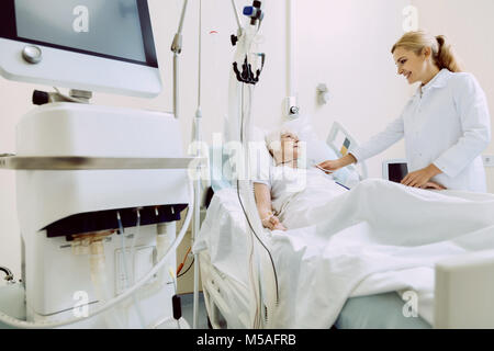Friendly medical worker supporting elderly patient Stock Photo