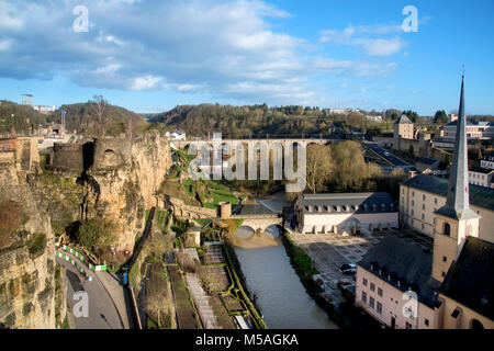 the Alzette River in Luxembourg City, Luxembourg, highlighting the Neumunster Abbey and the Saint-Jean-du-Grund Church on the right and the remains of