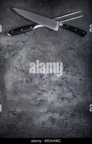 Fork and knife. Fork and knife crossed  on concrete board. Stock Photo