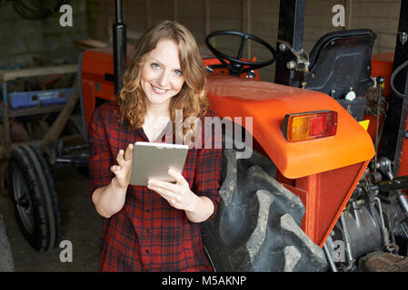 Portrait Of Female Agricultural Worker On Farm Using Digital Tablet Stock Photo