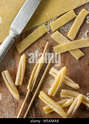 Traditional Italaian Casarecce pasta being made and shaped in a rustic setting Stock Photo