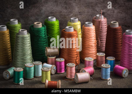Various vintage French spools of thread on a dark background Stock Photo