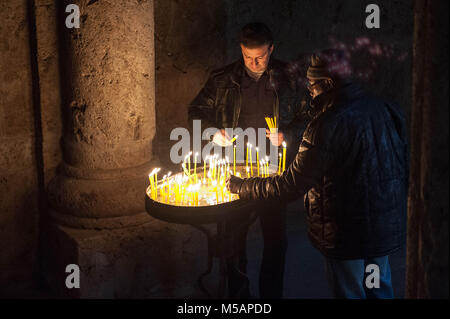 Two man burning candles in the corner of the Gosh Church. Stock Photo