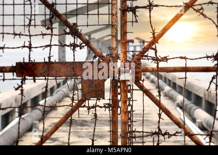 The rusty chains and old lock door in the block zone photo in sunset time warm and low lighting Stock Photo