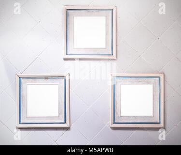 Three squared frames with pastel colours on a white tile wall Stock Photo