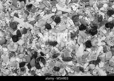 Muesli background - mixed fruit and nuts with cereal flakes and seeds as an abstract texture - monochrome processing Stock Photo