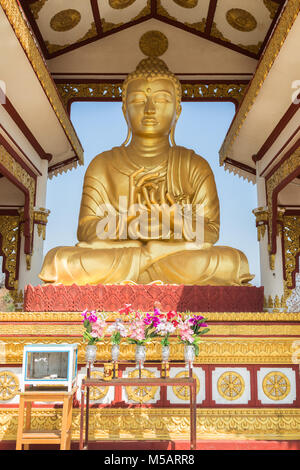 Front view of a golden statue of Buddha in lotus position on the Sagaing Hill in Mandalay, Myanmar (Burma) on a sunny day. Stock Photo