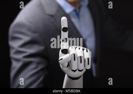 Close-up Of A Businessperson With Robotic Arm Touching Screen Stock Photo