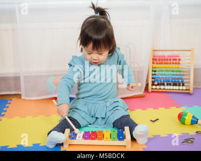 baby girl play xylophone at home Stock Photo