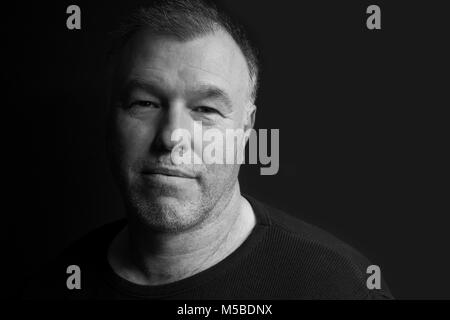 Black and white low key portrait of middle-aged man Stock Photo