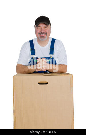 Portrait of smiling man leaning against large cardboard box on white background Stock Photo