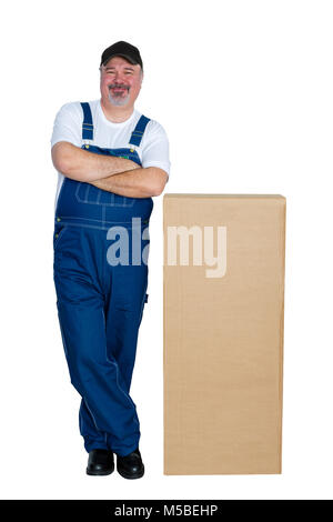 Happy delivery man standing by large cardboard box against white background Stock Photo