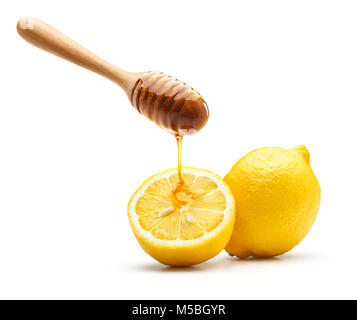 Honey dripping on fresh lemon isolated over white background Stock Photo