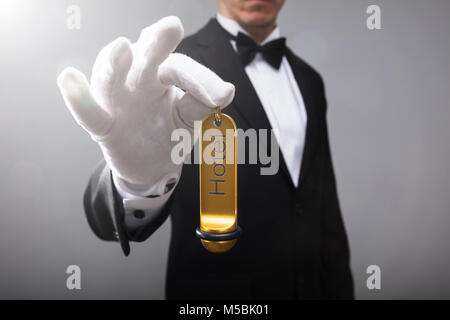 Close-up Of A Receptionist's Hand Holding Hotel Door Key Stock Photo
