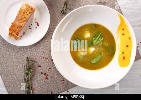 Sorrel soup in a white bowl, on a wooden table Stock Photo