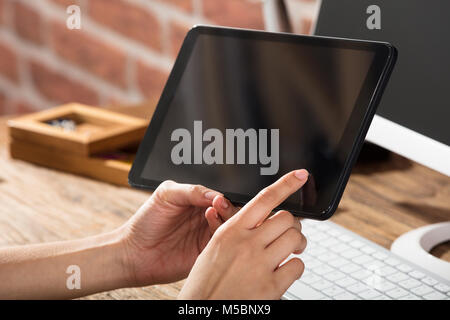 Close-up Of A Woman Looking At Digital Tablet With Blank Screen At Workplace Stock Photo