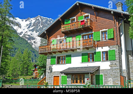 Italian mountain house with green shutters in front of Italy's highest mountain, the Monte Rosa Stock Photo