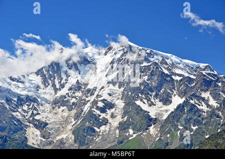 The summits of Monte Rosa in the Italian Alps with small fair weather clouds clinging to the tops in the summer. The highest mountain in Italy Stock Photo