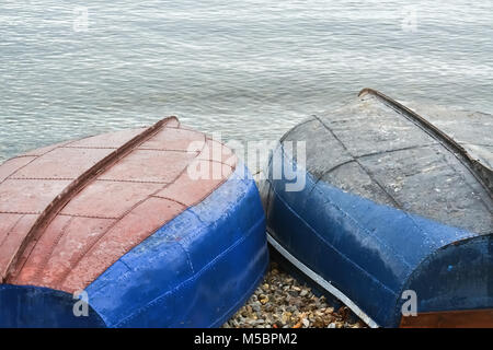 Two fishing boats turned upside down on the beach by the lake Stock Photo