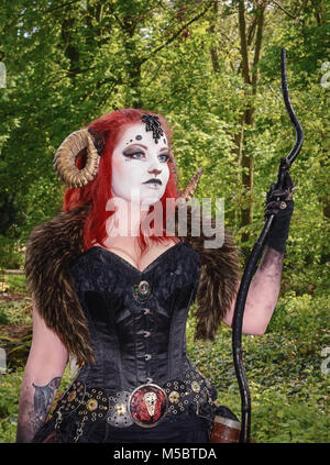 April  19, 2014, Haarzuilens, The Netherlands: Beautiful red haired woman wearing ram horns at the Elf Fantasy Fair (Elfia), an outdoor fantasy event  Stock Photo
