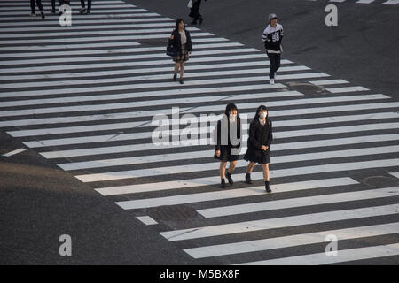 two school girls cross the street at Shibuya scramble, Tokyo Stock Photo