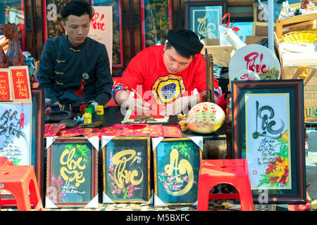 Vietnamese scholar writes calligraphy at lunar new year calligraphy festival is a popular tradition during Tet holiday Stock Photo