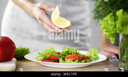 Cooking lady holding lemon piece for salad dressing, calories limit, fresh food, stock footage Stock Photo