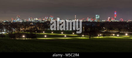 London, England, UK - February 2, 2018: Skyscrapers and landmarks in the London skyline are lit up at night as viewed from Primrose Hill, with Regent' Stock Photo