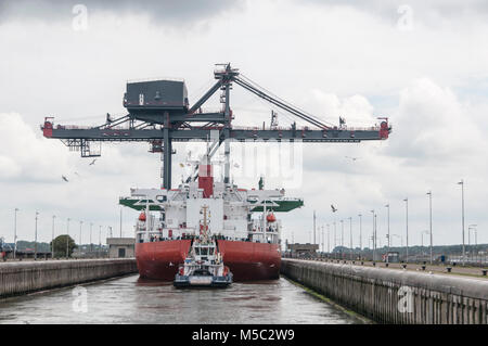 loading ship with huge crane on deck docked in the north sea canal Stock Photo
