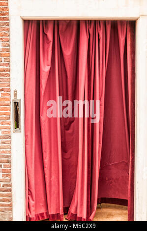 red curtain hung in a doorway Stock Photo