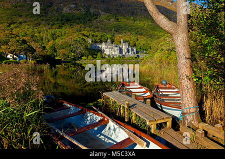 Rowing boats moored on Fannon Pool in front of Kylemore Abbey, a Benedictine monastery founded in 1920 on the grounds of Kylemore Castle  for Benedict Stock Photo