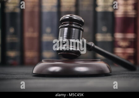 Law and Justice, Legality concept, Judge Gavel on a black wooden background in front of a law library. Stock Photo