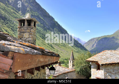 roof of house of a old village with chimney  and bell tower of church in mountain Stock Photo
