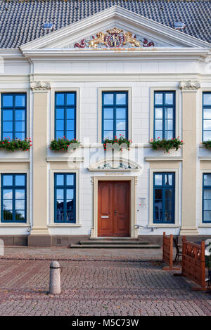 Frontal view of the entrance area of the two-storey town hall in Esens with parts of the window front in classical style and golden ornaments. Stock Photo