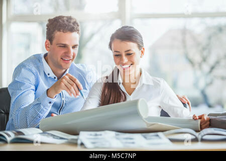 Young architects discussing over blueprint at office desk Stock Photo