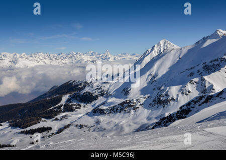 Panoramic view of wide and groomed ski piste in resort of Pila in Valle d'Aosta, Italy during winter. View Towards north is Switzerland and its iconic Stock Photo